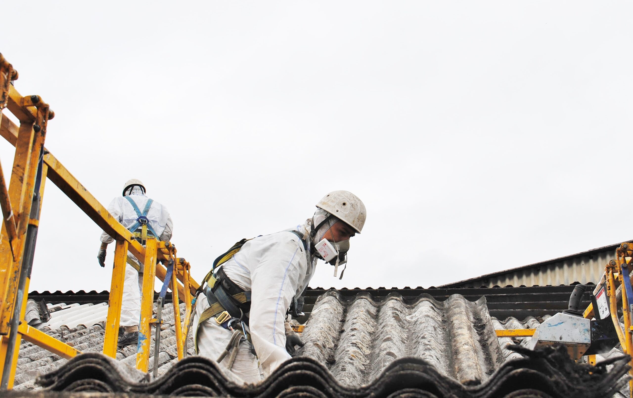 屋根を撤去するアスベスト作業員